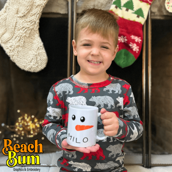 A young boy holding a personalized Christmas mug by a warm fireplace, showcasing a joyful holiday moment with a custom-designed mug in hand, radiating festive warmth and cheer.