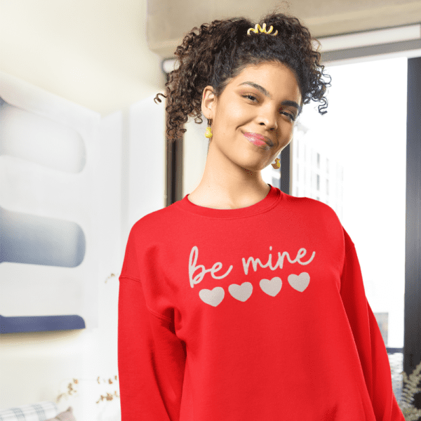 Red Be Mine Sweatshirt with a cozy and stylish design, perfect for expressing love and warmth. The text 'Be Mine' is prominently featured on the front, adding a romantic touch to the garment.