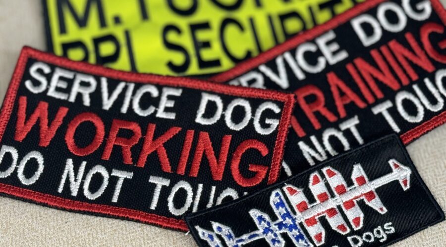 A variety of colorful embroidered patches, including hat patches, service dog patches, and name tags, showcasing the intricate designs and high-quality craftsmanship of Beach Bum Custom Apparel.